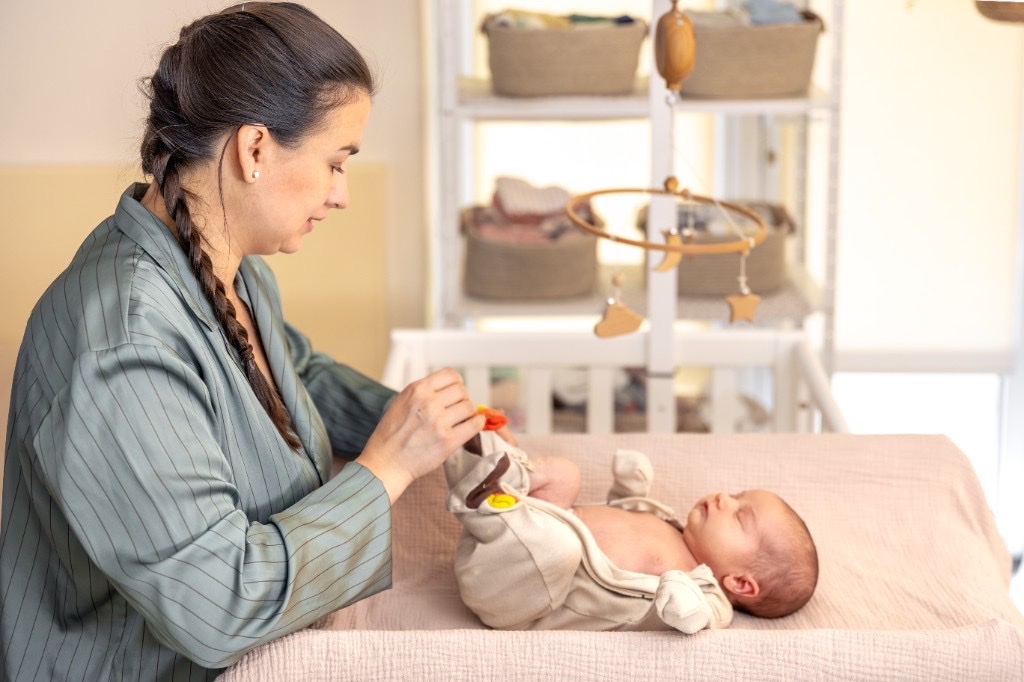 Nanny gently caring for a newborn at home
