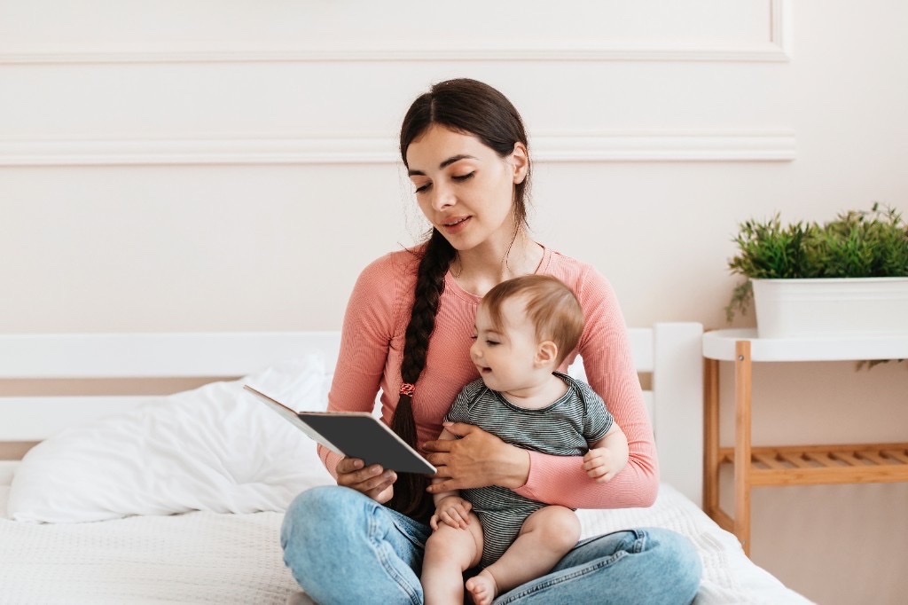 Nanny reading with a baby at home